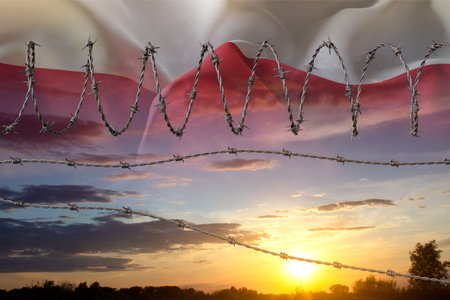 Barbed wire against the sunset with Poland flag