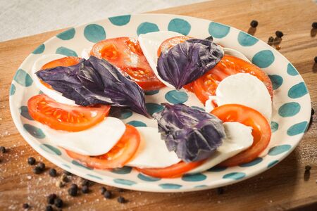 Caprese salad with mozarella cheese, tomatoes and basil.