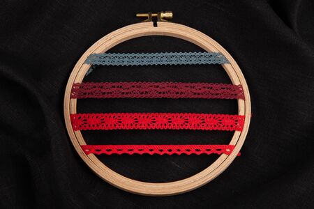 Set of red sewing ribbons on hoop over black background.の写真素材
