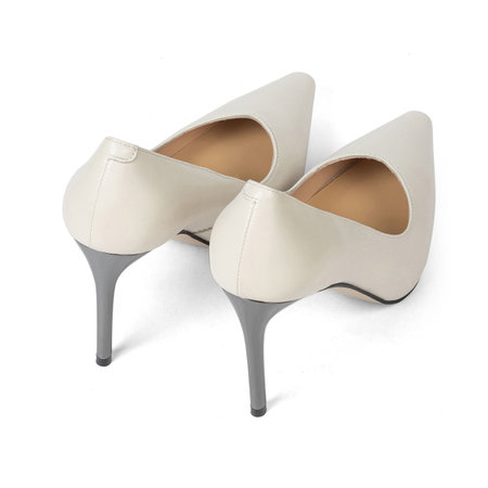 White women's classic shoes with a sharp toe with thin heels on a white background.の写真素材