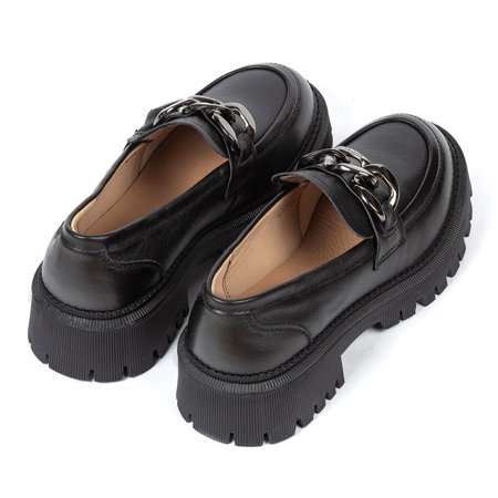 Black women's leather ankle boots on a thick rubber sole decorated with a metal chain on a white background.の写真素材