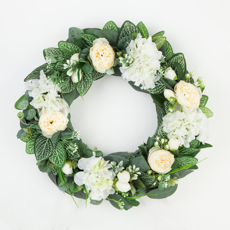 Beautiful green coniferous wreath made of natural materials top view on a white background.の写真素材