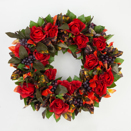 Beautiful green and red coniferous wreath made of natural materials top view on a white background.の写真素材