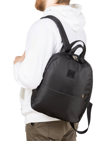 Young man with small balck backpack isolated on white background.の写真素材