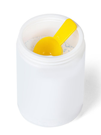 White plastic container with washing powder with yellow spoon isolated on white backgroundの写真素材