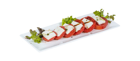A pristine white plate elegantly topped with succulent sliced tomatoes and creamy mozzarella cheese, creating a delightful visual and culinary experienceの写真素材