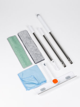 A neatly arranged set of mop heads and brushes placed on a clean white surface, showcasing their design and utilityの写真素材