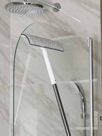 A unique shower head that comes with a convenient cleaning brush securely attached to it for easy maintenance and hygiene upkeepの写真素材