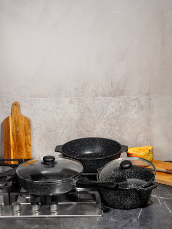 A collection of various pots and pans resting together on the surface of a stove, ready to be used for cooking delicious mealsの写真素材