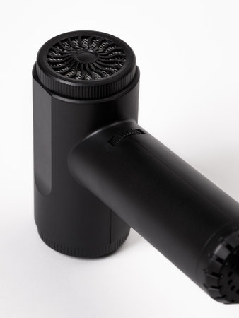 This image shows a detailed closeup shot of a sleek black object positioned prominently against a bright white surface, inviting inspection and intrigueの写真素材