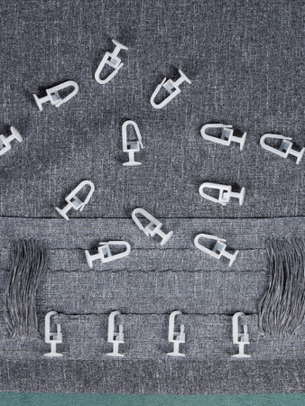 A white plastic hook is currently positioned on the surface of a gray carpet, creating a contrast...