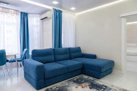 Stylish and inviting living room featuring a plush blue sofa and elegant curtains, perfect for a...