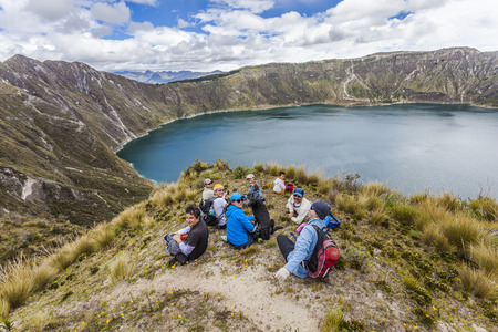 ZUMBAHUA, ECUADOR - APRIL 15: Group of hikers walking around the crater of Quilotoa lake, taking a break on april 12 2014, Zumbahua, Ecuadorのeditorial素材