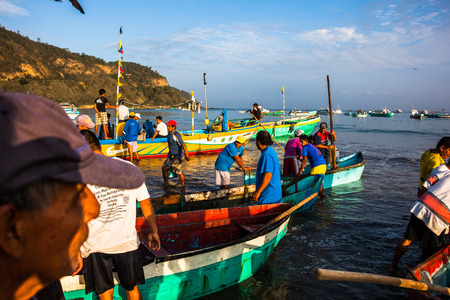 Puerto Lopez, Ecuador, June 30, 2015: Group of fishermen with their boats landing on the beach in Puerto Lopez, to deliver their catch to fish traders.のeditorial素材