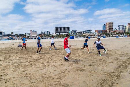Manta, Ecuador, September 28, 2018: A group of unidentified students play soccer on the beach,...