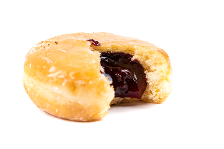 A frosted jelly filled donut with a bite out of it isolated on a white backgroundの写真素材