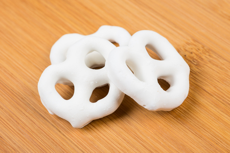 Yogurt covered pretzels isolated on wood backgroundの写真素材