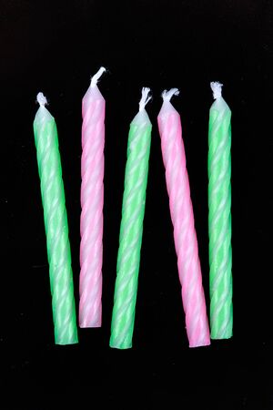 Assorted colored candles isolated on black backgroundの写真素材