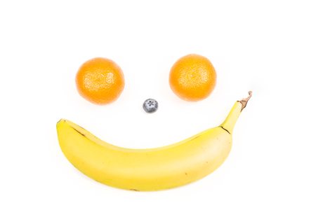 Happy fruit face with banana, blueberry and oranges isolated on white backgroundの写真素材