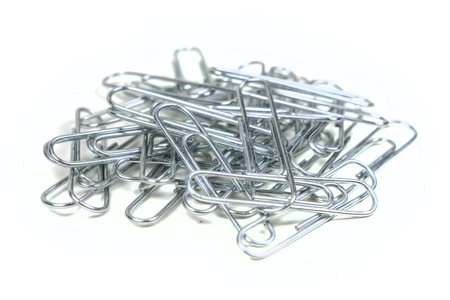 Pile of silver paperclips isolated on white backgroundの写真素材