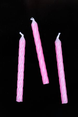 Assorted colored candles isolated on black backgroundの写真素材