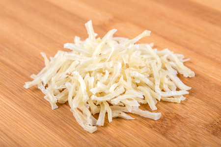 Sliced dried potatoes isolated on wood backgroundの写真素材