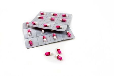 Pink and white pills in blister packs isolated on white backgroundの写真素材