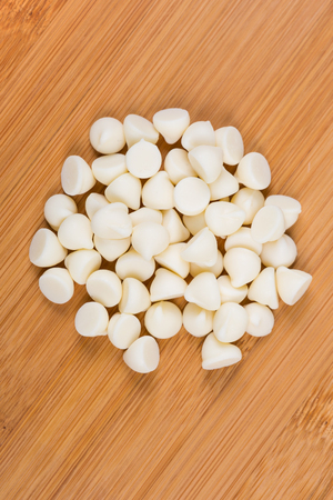 Vanilla baking chips isolated on wood backgroundの写真素材