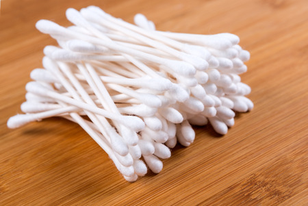 Pile of white cotton swabs isolated on wood backgroundの写真素材