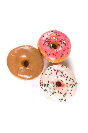 Raised frosted donuts isolated on a white backgroundの写真素材