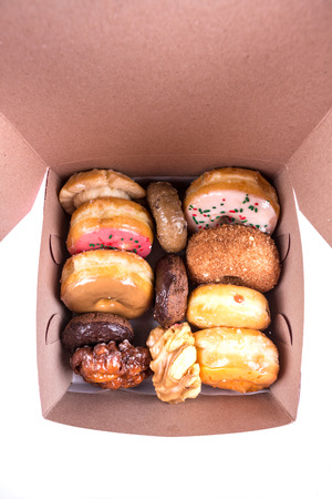 An assorted dozen donuts in a box isolated on a white backgroundの写真素材