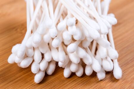 Pile of white cotton swabs isolated on wood backgroundの写真素材