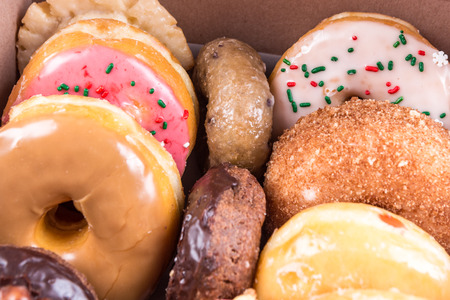 An assorted dozen donuts in a box isolated on a white backgroundの写真素材