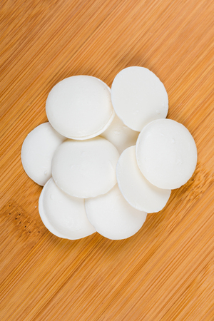Vanilla candy melts isolated on wood backgroundの写真素材