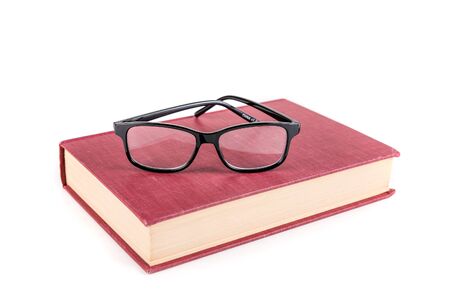Book with reading glasses isolated on white backgroundの写真素材