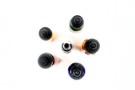 Assorted flavors of vape juice and an ecigarette overhead view isolated on white backgroundの写真素材