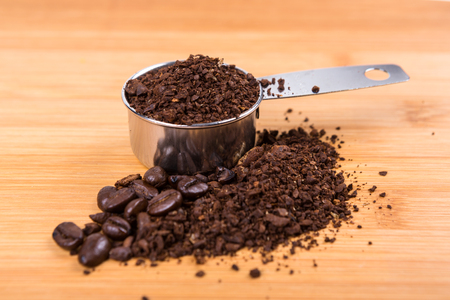 Coffee beans and grounds isolated on wood backgroundの写真素材