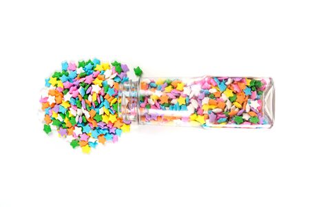 Assorted rainbow colored sprinkles and bottle isolated on white backgroundの写真素材