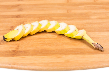 Banana cut up shallow depth of field isolated on wood backgroundの写真素材