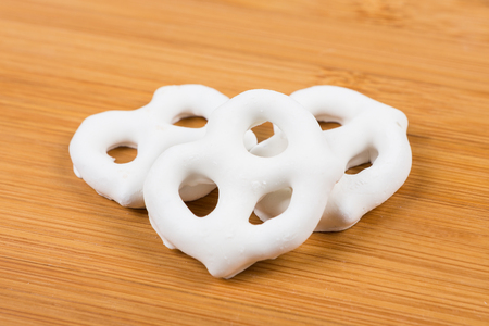 Yogurt covered pretzels isolated on wood backgroundの写真素材