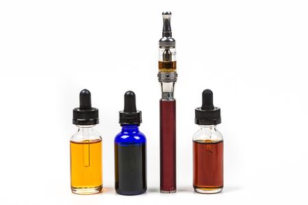 Flavored vape juice and ecigarette with shallow depth of field and objects out of focus isolated on white backgroundの写真素材