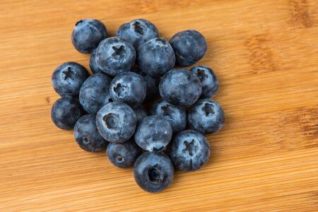 Pile of blueberries isolated on wood backgroundの写真素材