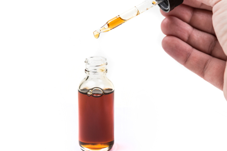 Assorted flavors vape juice and eyedropper being used isolated on white backgroundの写真素材