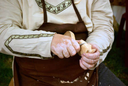 Hungarian wood carver in folk costume creating a spoon with horses head handle の写真素材
