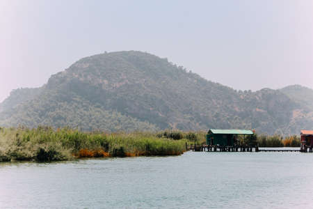 Azmak River, Akyaka, Mugla, Turkey. Nature composition. Summer Background. Countryside landscape with lake. Boat sails on the Azmak River. People are taking tour on Azmak River in Akyaka Village.のeditorial素材