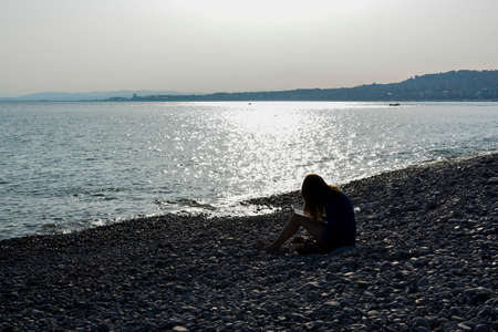 NICE, FRANCE - MARCH 13: The beach is a great place to relax and read a book, especially in the off season when the crowds are low, Nice, France on March 13 2014. のeditorial素材