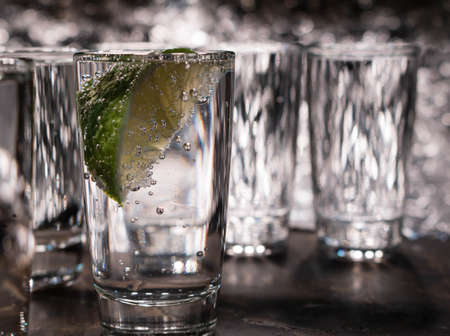 Glass of cool water with a slice of lime on a gray backgroundの写真素材