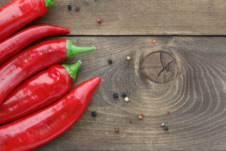 Top view of fresh red hot chili peppers on a wooden table. Copy space.