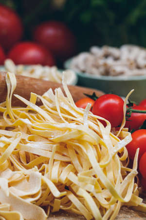 Close-up of unprepared italian pasta with fresh tomatoesの写真素材