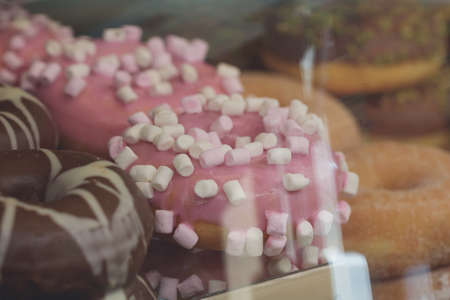 Close-up of donuts in a shop windowの写真素材